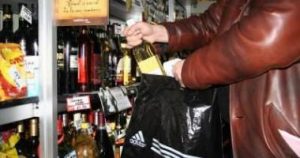 Femeie prinsă cu sticla de alcool în geantă
